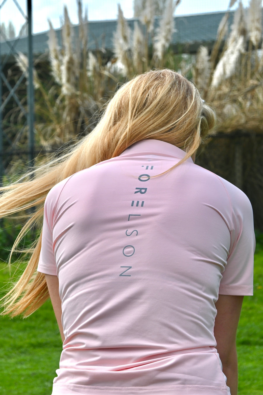 Women's pink golf zip polo shirt. Lightweight breathable fabric.