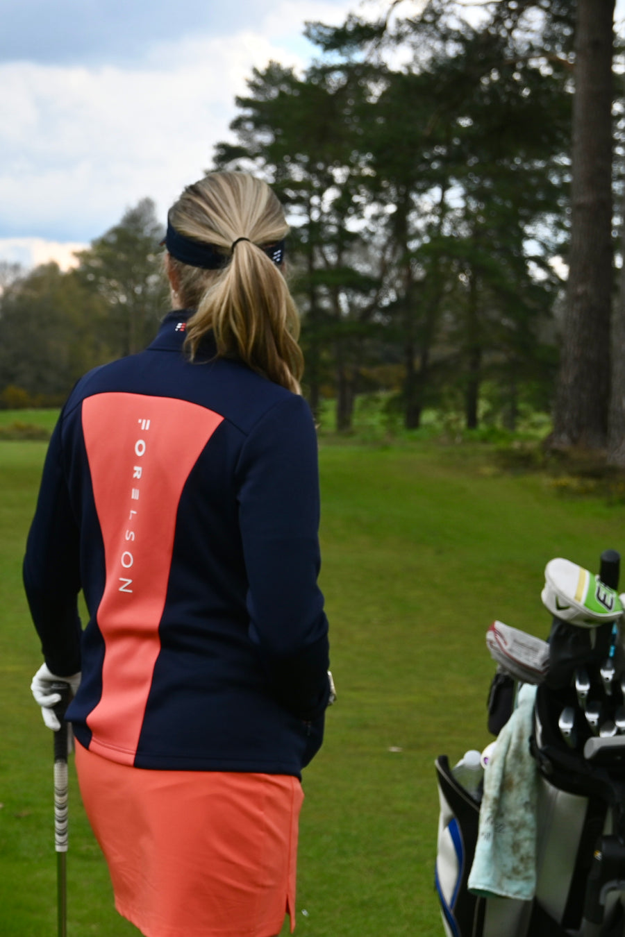 Women's navy and orange zip up golf jacket. Soft fabric that will stretch, allowing movement.