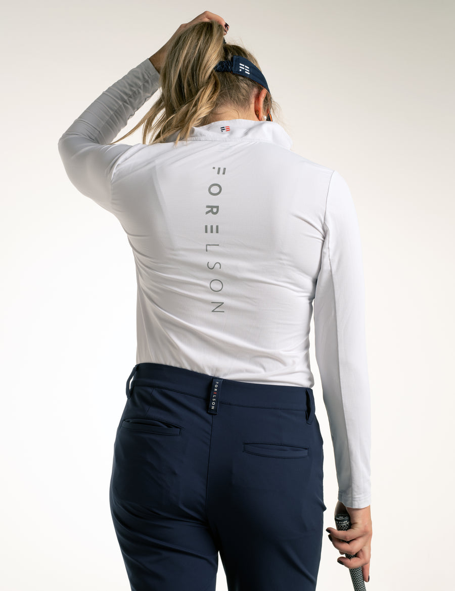Women's white golf under-layer. Long sleeved, zip up, polo collar. Lightweight, wicking qualities.