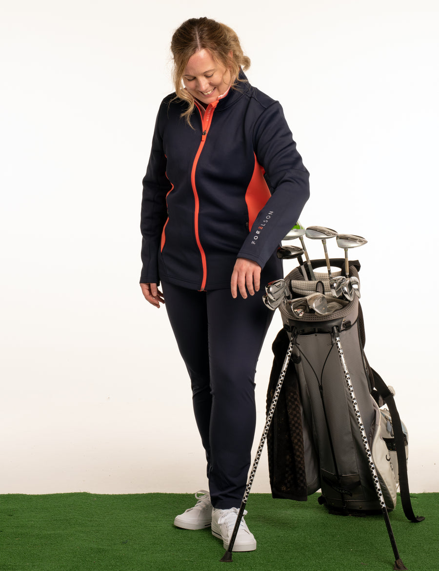 Women's navy and orange zip up golf jacket. Soft fabric that will stretch, allowing movement.