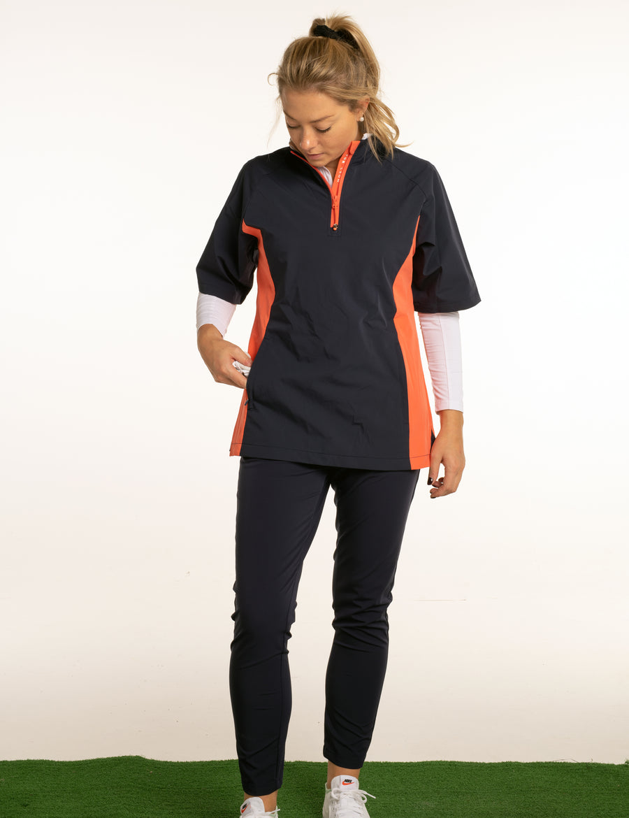 Women's navy and orange, short sleeved golf jacket. Water resistant windbreaker, lightweight material.